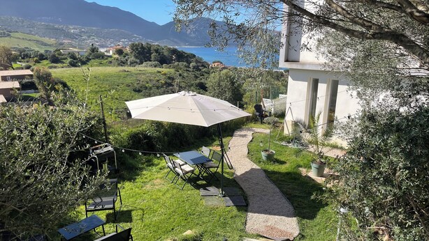 A patio with outdoor seating, a pathway, and a view of the sea and mountains. - Bas De Villa 60m² + Jardin au Golfe de Lava (Appietto)