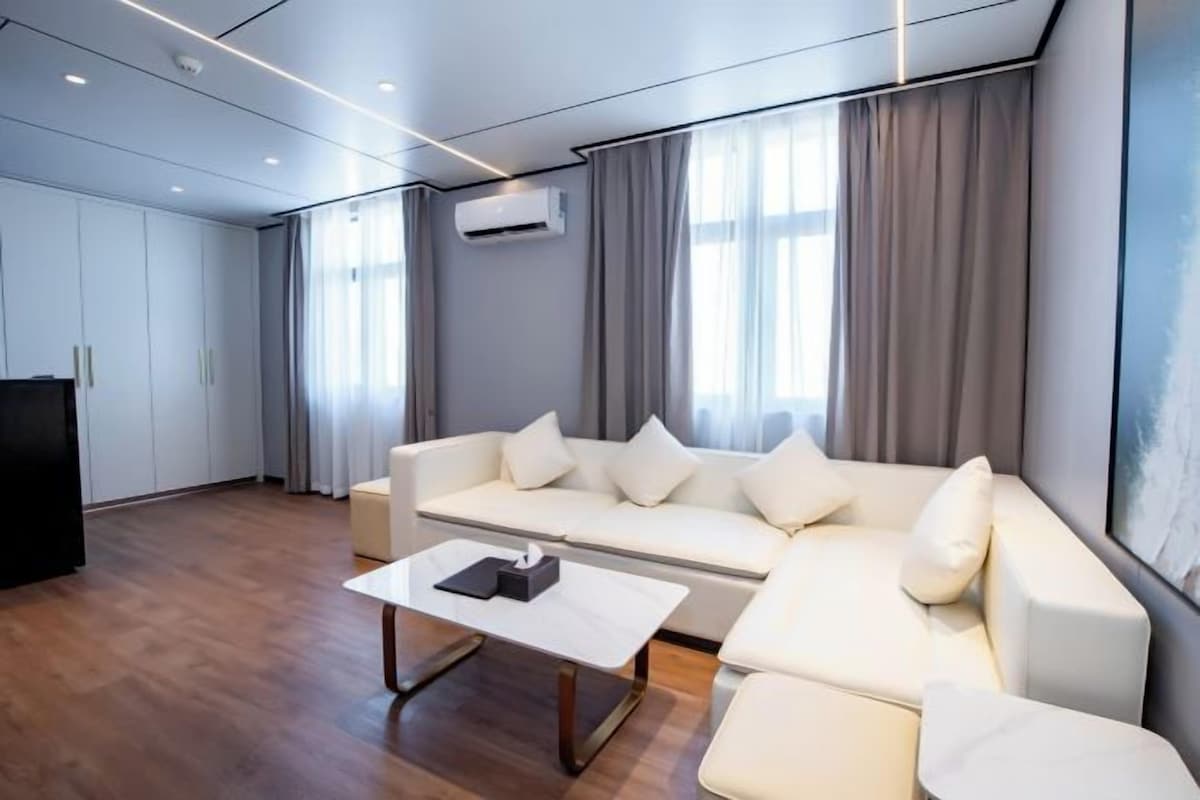 Uma sala de estar moderna com um sofá, uma mesa de centro e uma televisão.