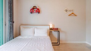 A bedroom with a bed, pillows, a bedside table, a lamp, a key hanger, and a decorative car model. - Goseong Araenmaru Pension (Goseong)