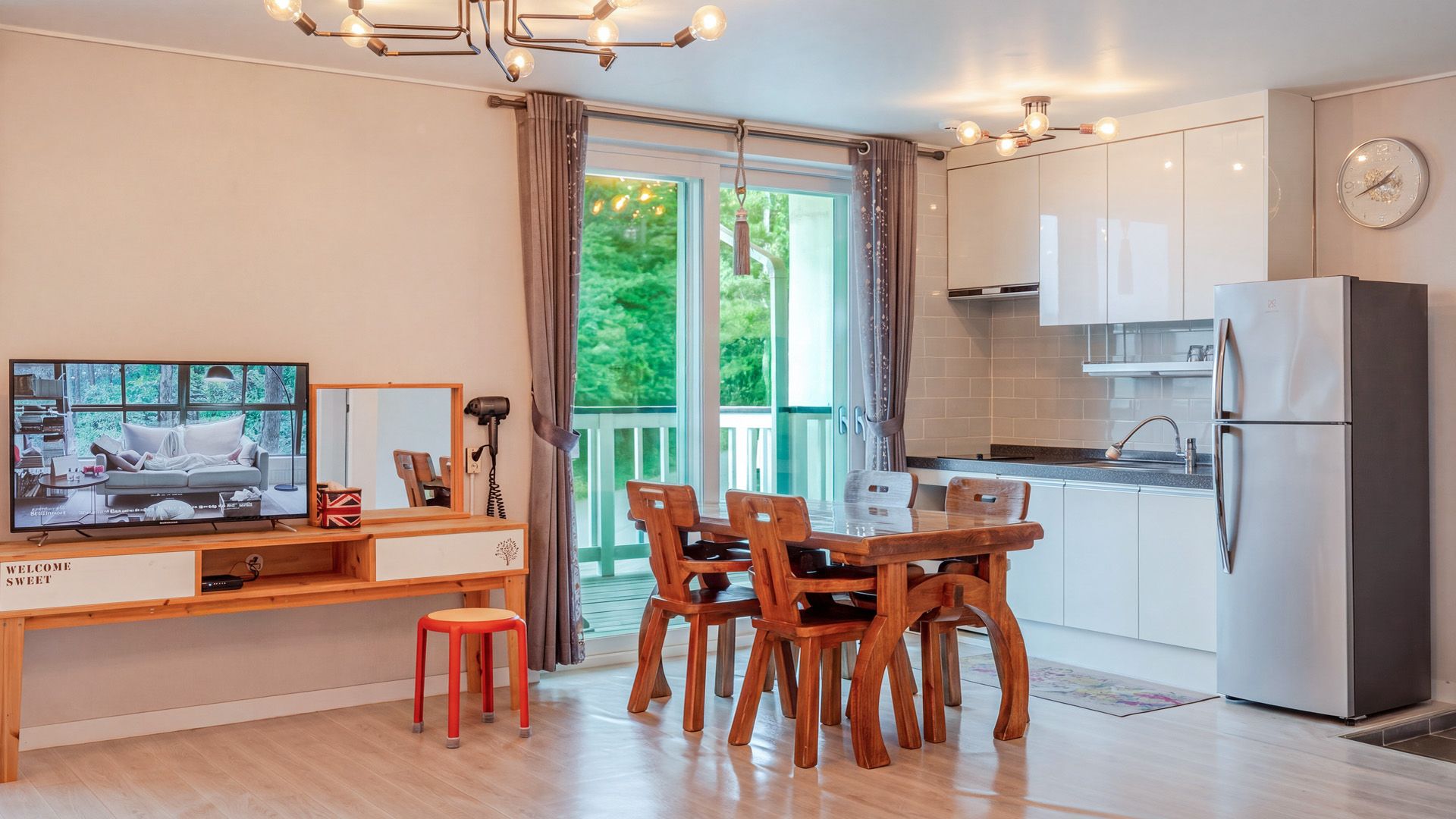 Una cocina moderna con comedor, televisión y vistas al exterior.