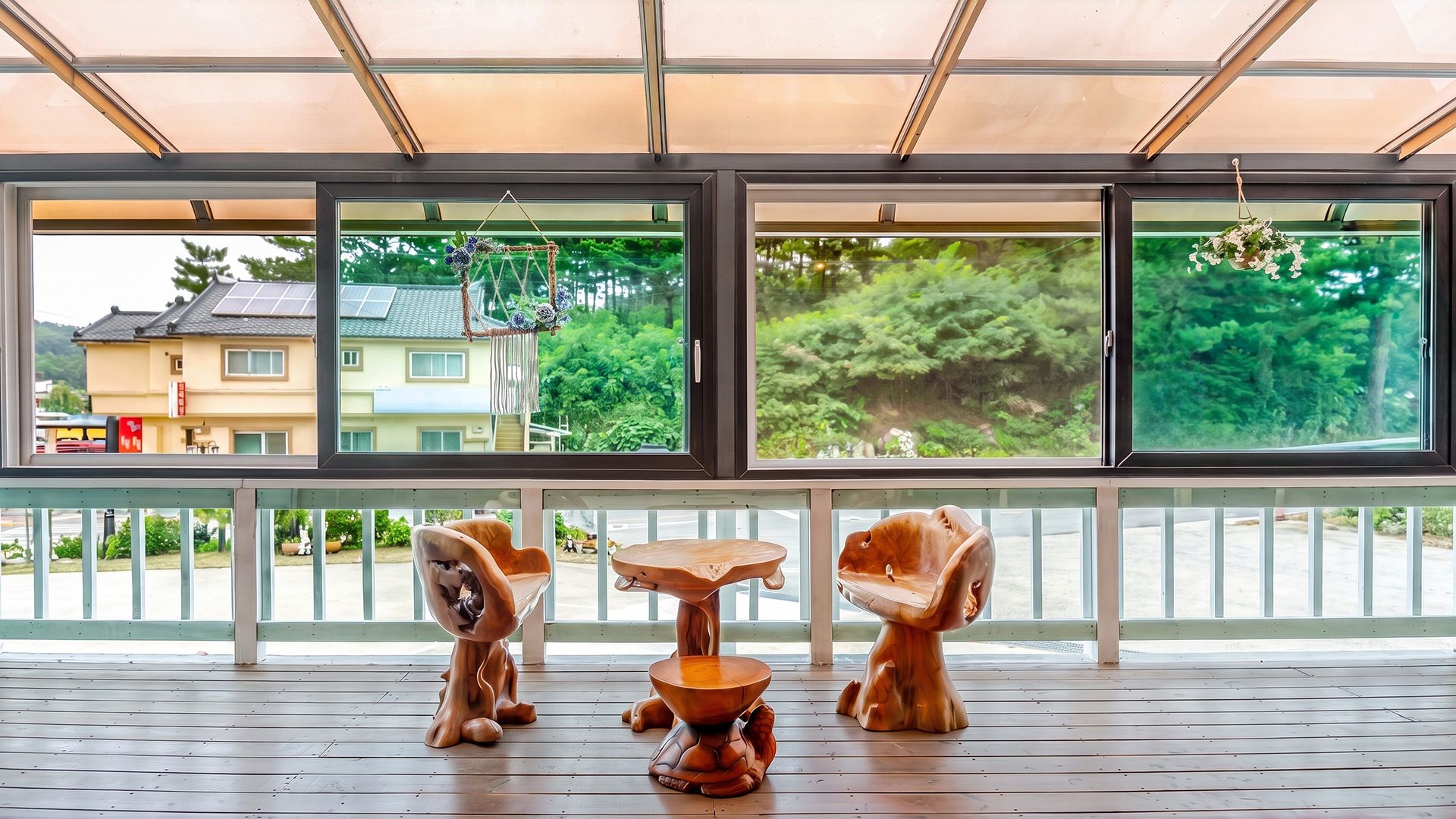 Una habitación con un ventanal grande, una mesa de madera y dos sillas de madera.