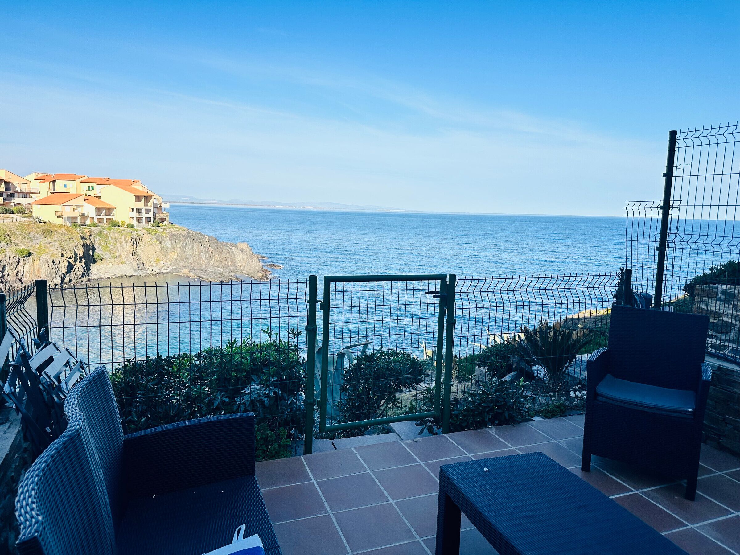A patio with outdoor furniture overlooking a coastal view.
