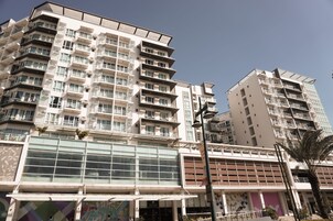 A multi-story building with balconies and large windows.