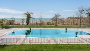 A rectangular swimming pool with a clear view of the ocean in the background.