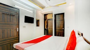 Una habitación de hotel con una cama, un televisor y dos puertas.