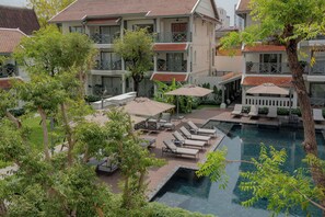 Un hôtel doté d’une piscine, d’un espace extérieur aménagé et de plusieurs balcons.