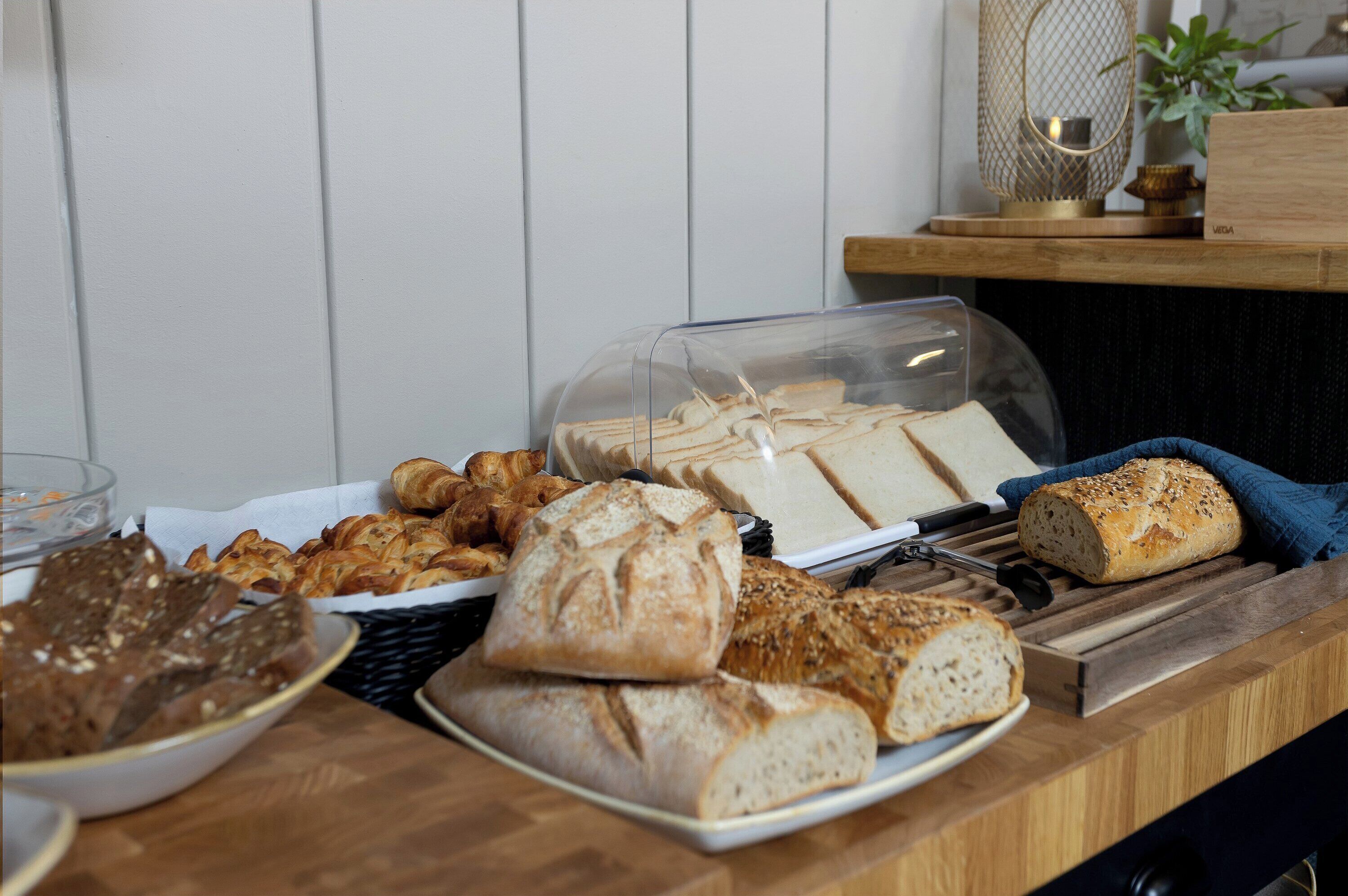 A buffet with various breads and pastries.