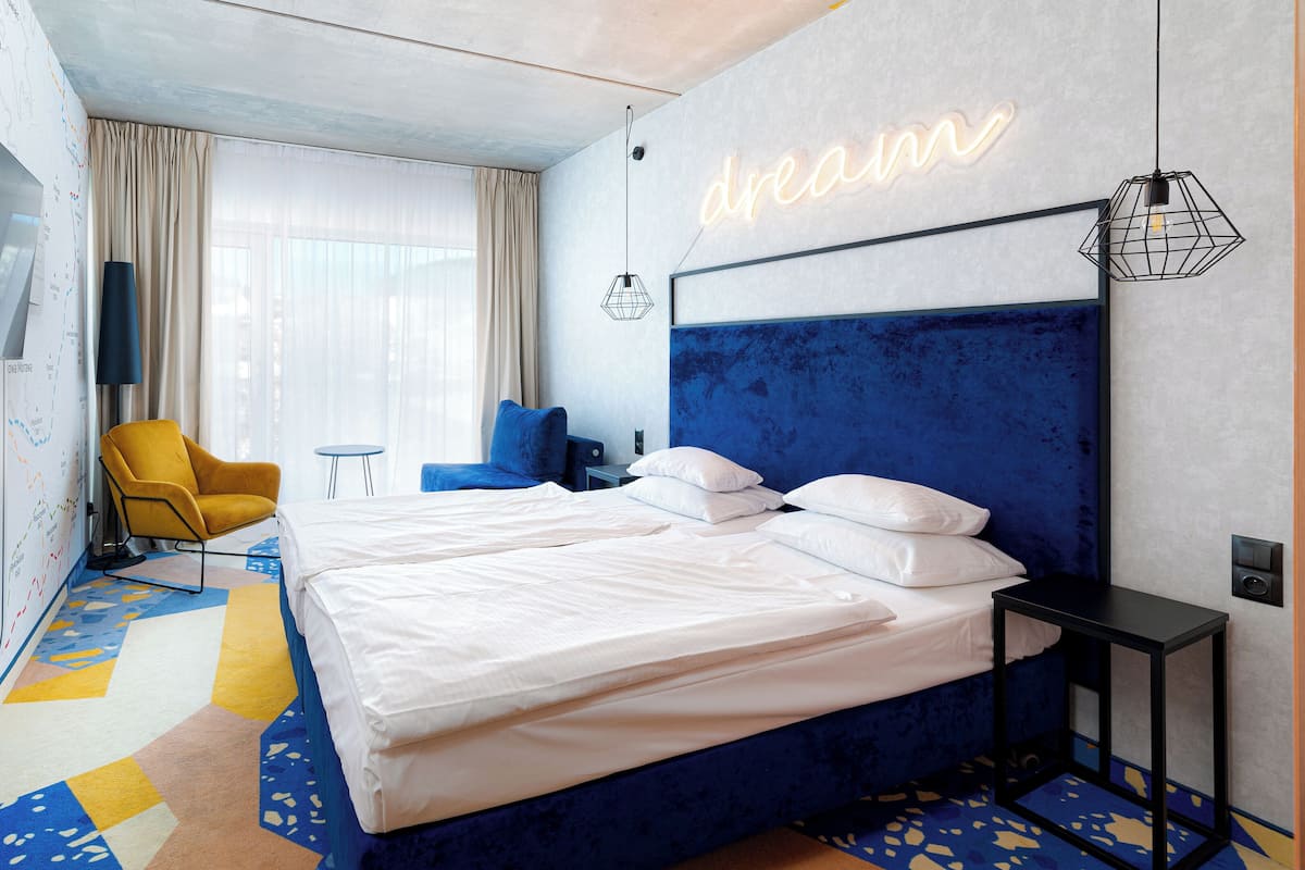 Une chambre d’hôtel avec un grand lit, une télévision, une carte accrochée au mur et une pancarte indiquant « endroit idéal ».