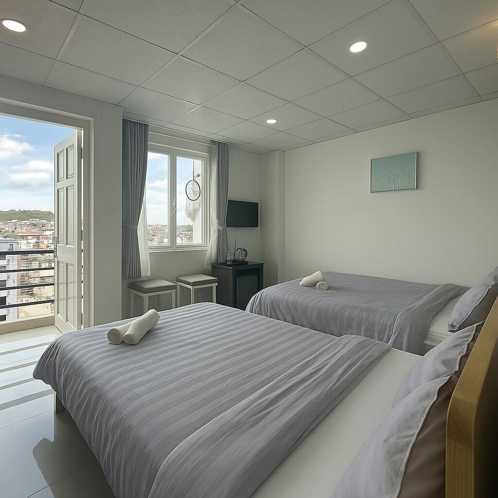 A hotel room with two beds, a television, a small table, and a window with curtains.