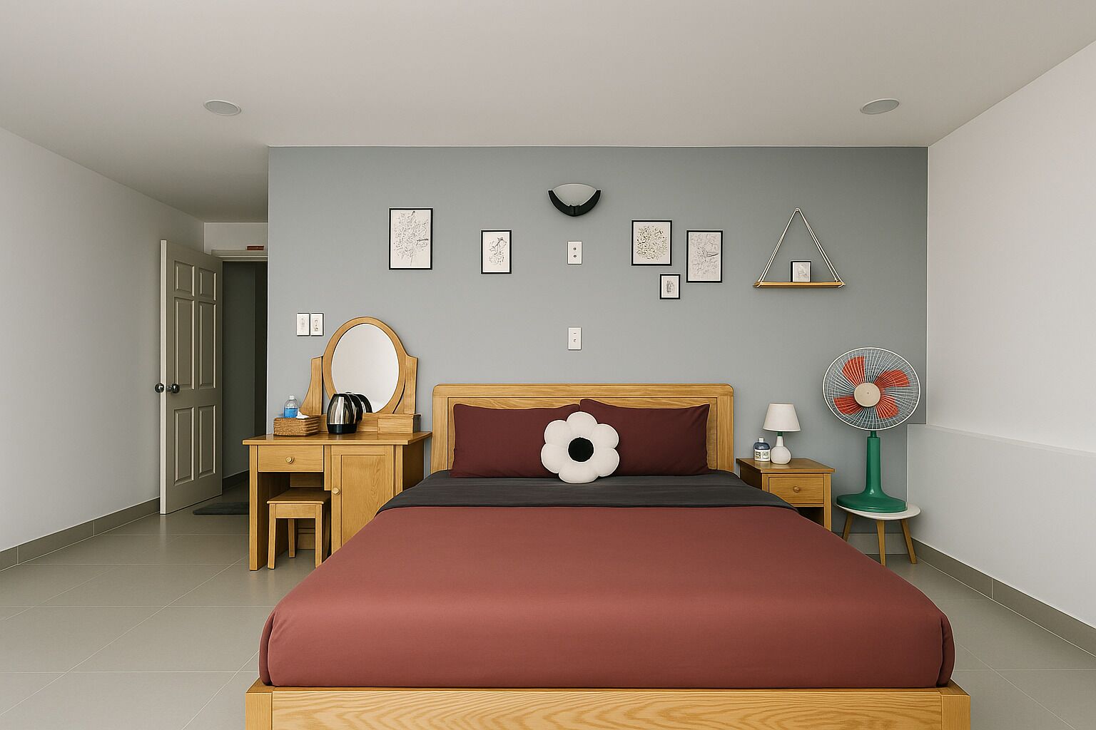 Un dormitorio con una cama grande, un aparador de madera, un espejo, una mesita de noche con lámpara, un estante en la pared y un ventilador de pie.