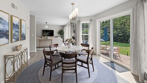 A dining area with a round table, six chairs, and a chandelier. - Last Minute Deal ! New Construction 3 blocks to Boone St. and walkable to ocean wall (Narragansett)