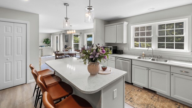 A modern kitchen with a large island, white cabinetry, and pendant lighting. - Last Minute Deal ! New Construction 3 blocks to Boone St. and walkable to ocean wall (Narragansett)