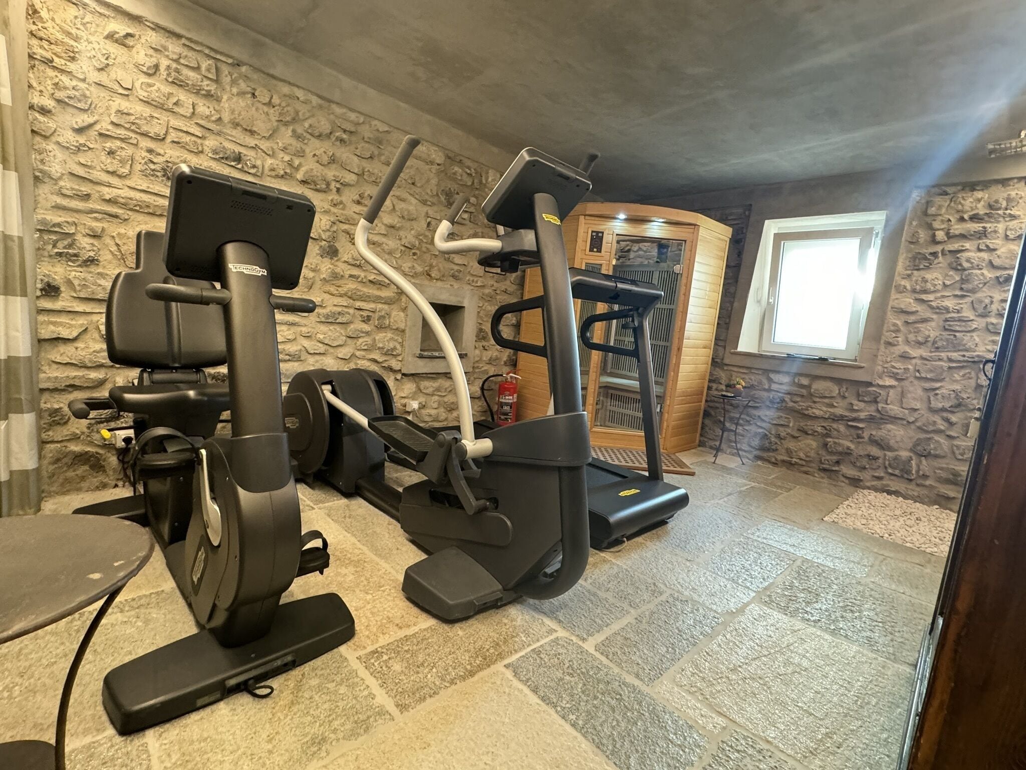 A home gym with a stationary bike, elliptical, and treadmill.