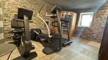 A home gym with a stationary bike, elliptical, and treadmill.
