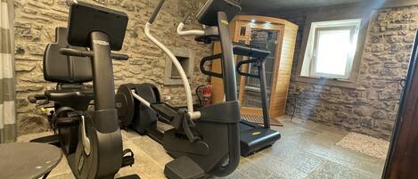 A home gym with a stationary bike, elliptical, and treadmill.