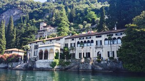 A historic building with multiple arches and a waterfront view. - Al Molo 5 Apartments (Oliveto Lario)
