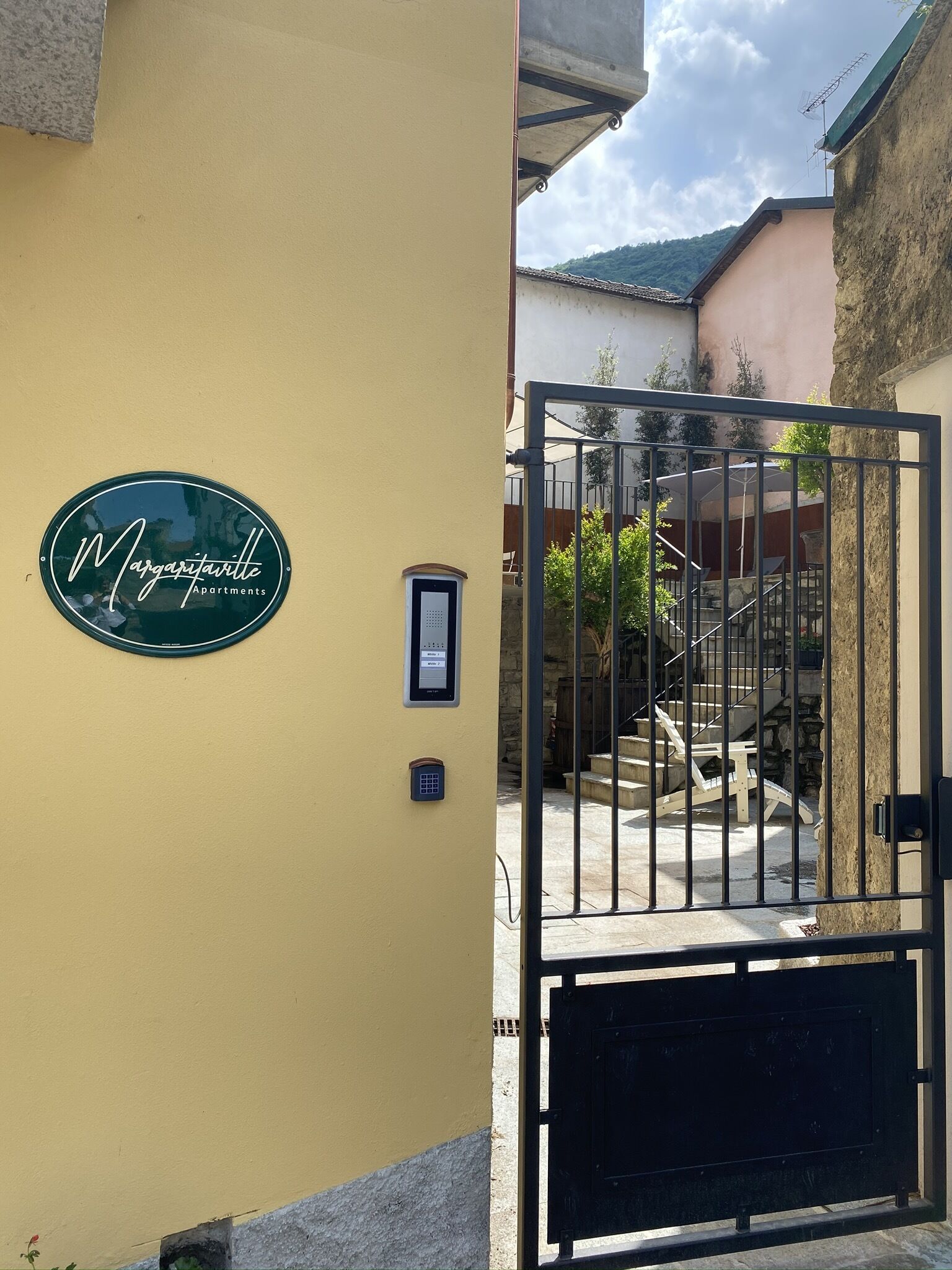 A yellow building with a sign reading "Margaritaville Apartments" and a gated entrance.