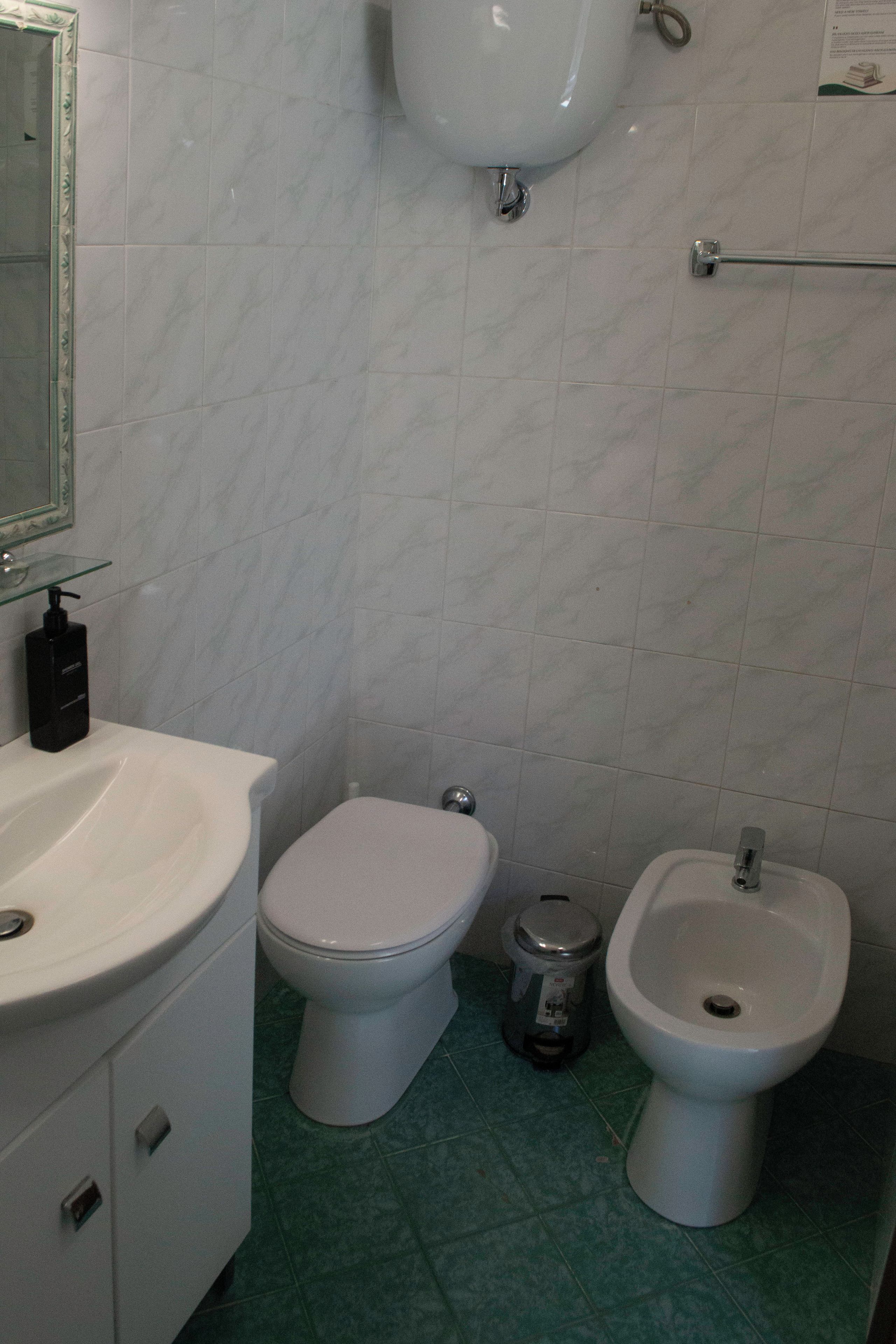 A bathroom with a toilet, bidet, and sink.