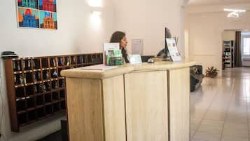 Un comptoir d’accueil avec un présentoir, un porte-clés fixé au mur et un tableau encadré au-dessus.
