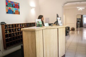A reception desk with a counter, a wall-mounted key rack, and a framed picture above. - Hotel Domus Rome (Rome)