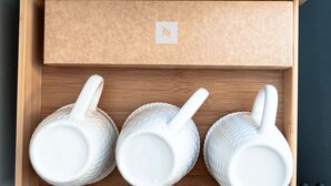 A wooden box with a label containing a letter 'N'. Inside, there are three white ceramic mugs with handles. - Hotel Domus Rome (Rome)