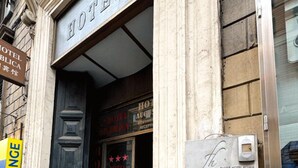 A hotel entrance with a sign indicating the Domus Rome hotel on the second floor. - Hotel Domus Rome (Rome)