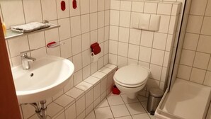 A bathroom with a sink, toilet, and shower.