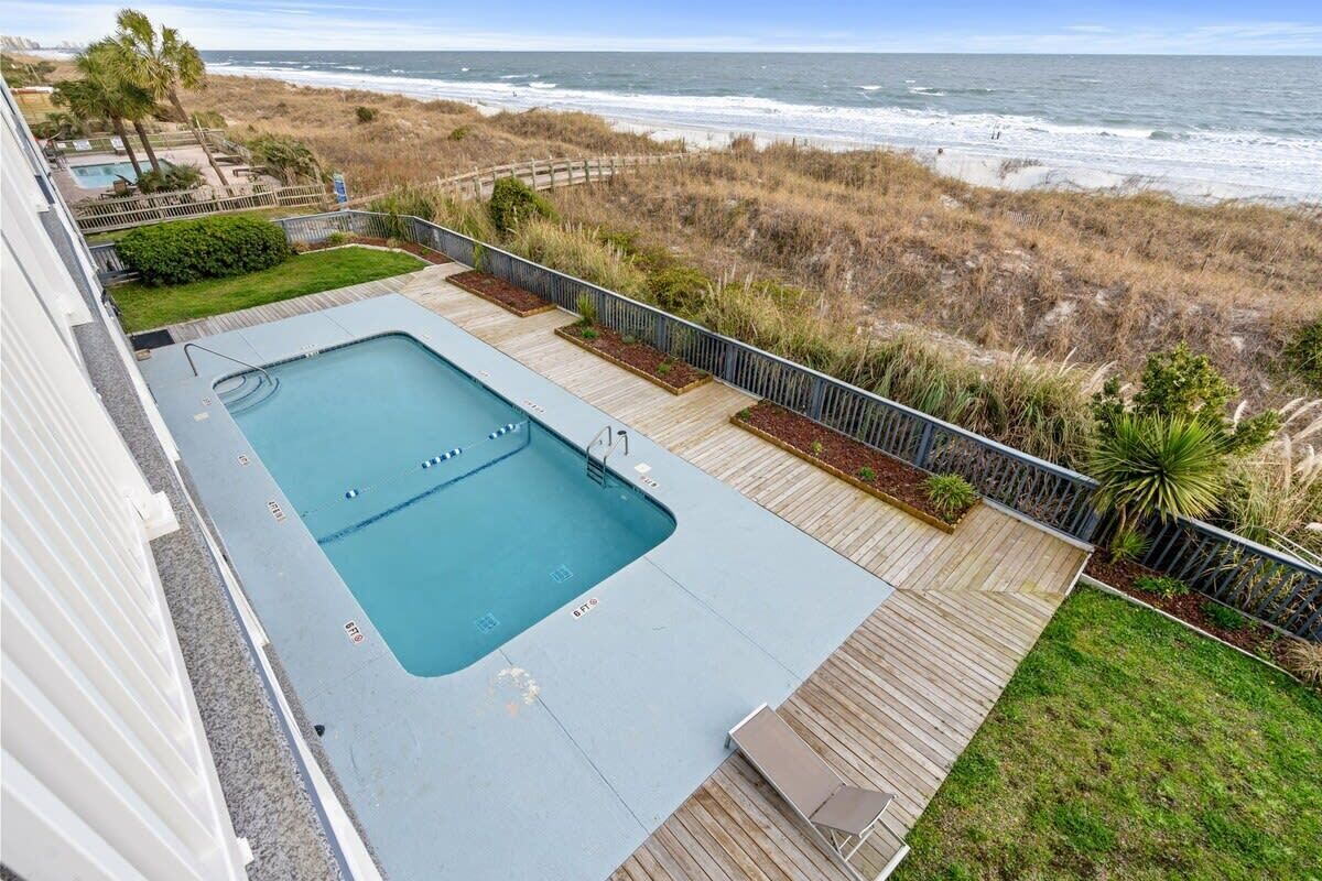 Une piscine sur le toit offrant une vue sur l’océan et la plage.