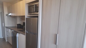 Una cocina moderna con electrodomésticos de acero inoxidable, lavavajillas y microondas.