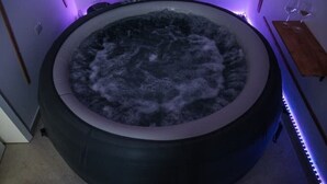 A hot tub with a circular shape and a wooden bench to the right. - 2 Bedroom Apartment in Cutrofiano (Cutrofiano)