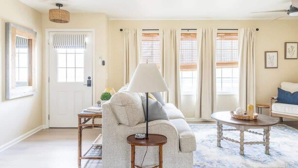 A living room with a sofa, a round coffee table, and a lamp.