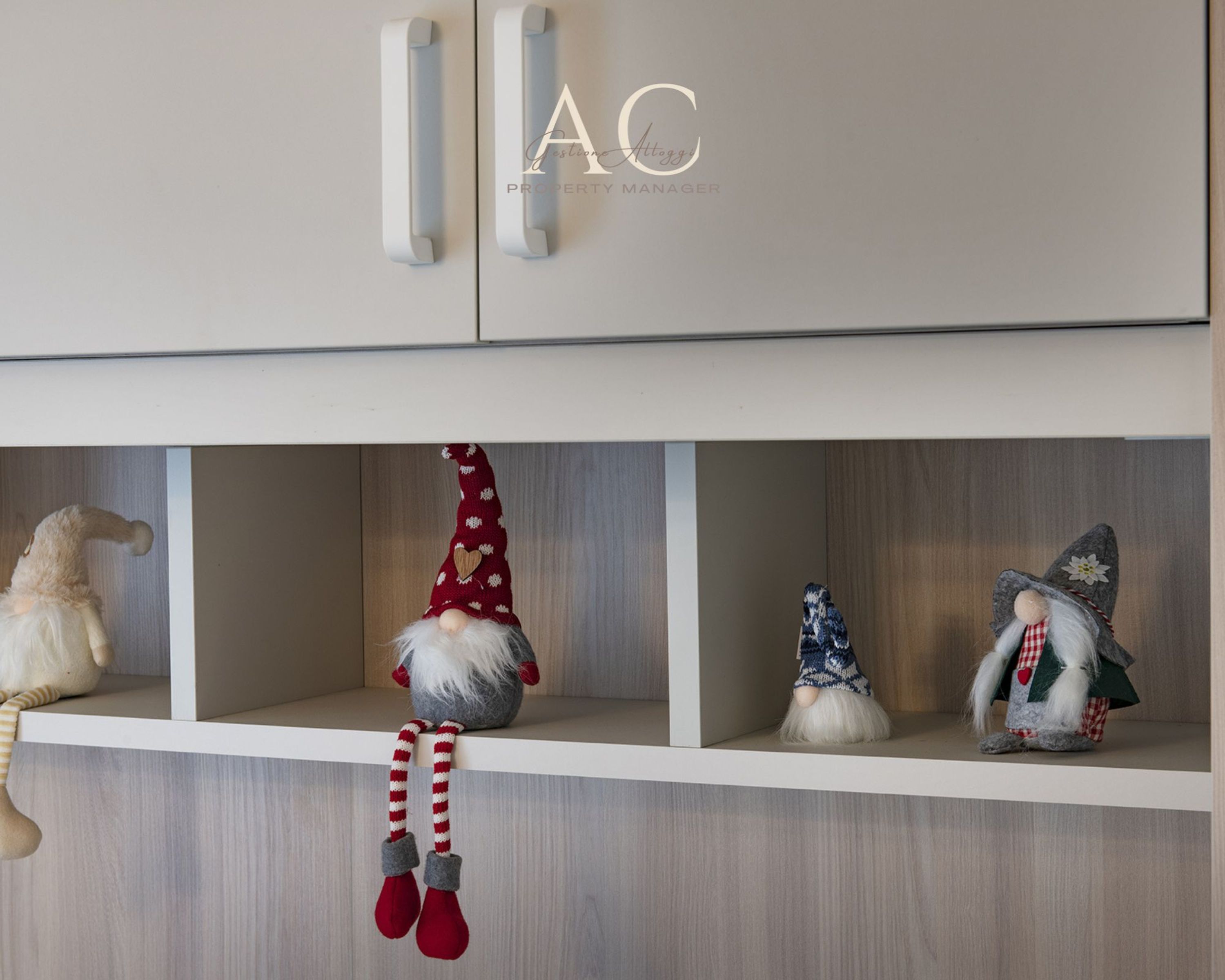 A property manager's office with a cabinet and three gnome decorations on shelves.
