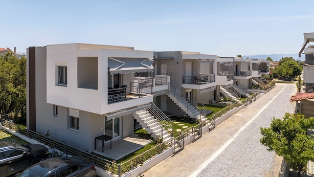 Una hilera de edificios modernos de varios pisos con balcones y terrazas.