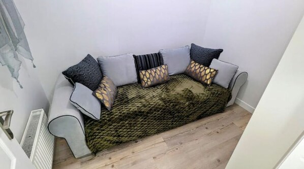 Un canapé agrémenté de coussins à motifs et recouvert d’un plaid à texture intéressante.