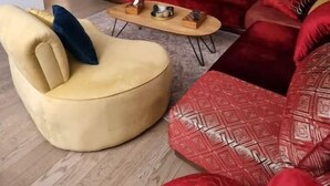 A modern living room with a blue accent wall, a red sofa set, a yellow armchair, and a coffee table. - JO bel Appart Proche Versailles (Louveciennes)
