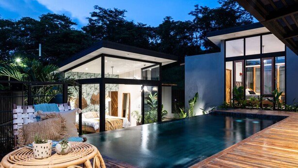 A modern house with a swimming pool, glass doors, and a wooden deck. - Boho Oasis in the heart of town (Tamarindo)