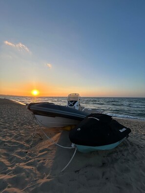 Na praia, areia branca, espreguiçadeiras, guarda-sóis 