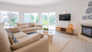 Un salon spacieux avec un canapé beige, une table basse et une cheminée.