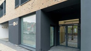 Un edificio moderno con una amplia fachada de vidrio y una entrada negra.