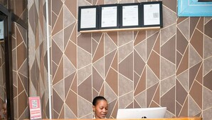 Un comptoir d’accueil avec une enseigne indiquant « Comfort Inn, plage de Mbezi ».