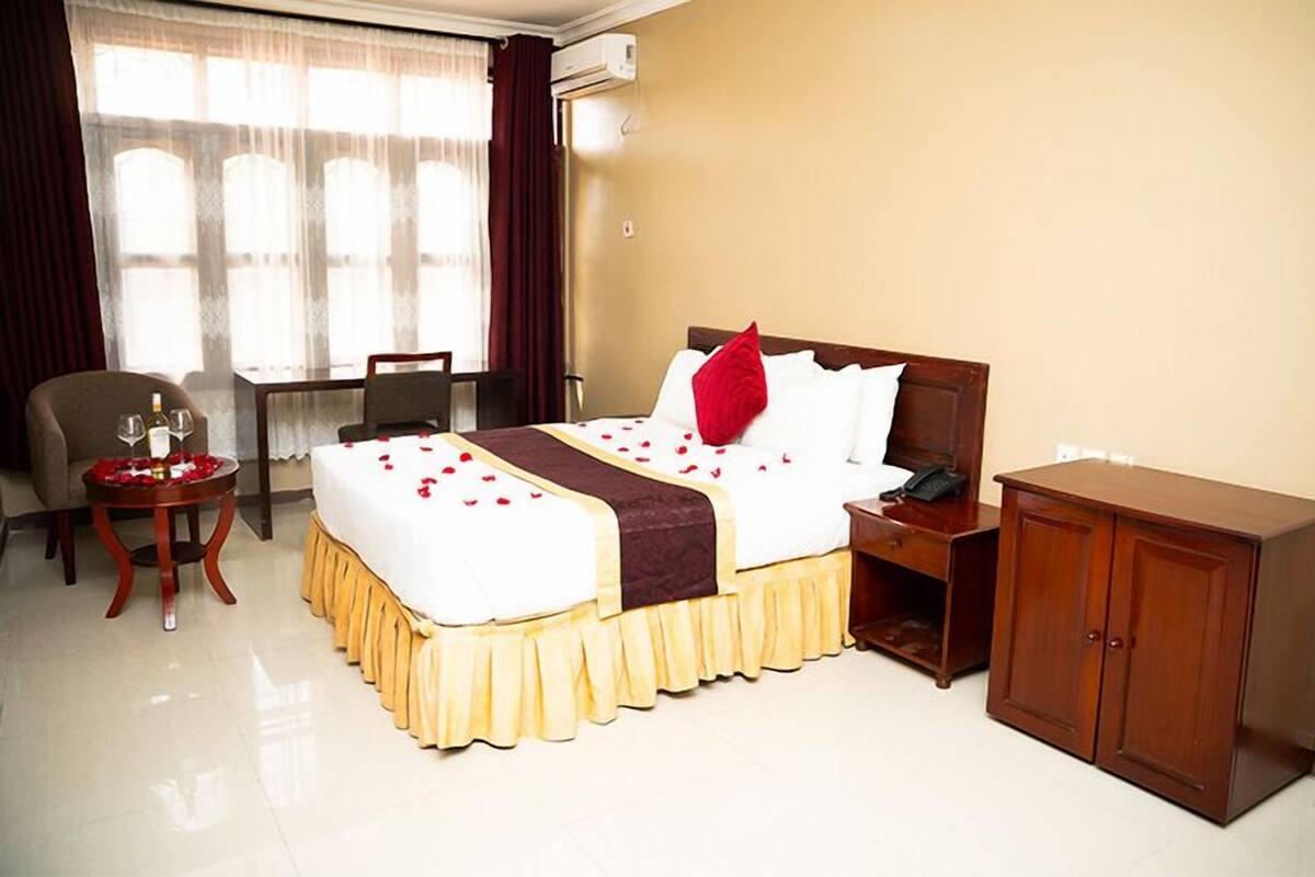 Ein Hotelzimmer mit Bett, Nachttisch, Stuhl und Schreibtisch.