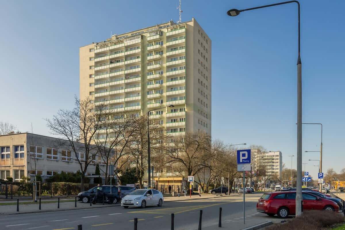 Un immeuble à plusieurs étages avec un panneau indiquant un espace de stationnement.