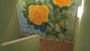 A staircase with a green wall and a mural of orange roses.