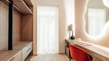 Un dormitorio moderno con un armario de madera, un escritorio con silla y un espejo grande.