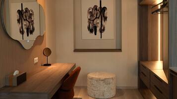 Una cocina moderna con una mesa de comedor de madera, dos sillas, un otomano de piedra redondo y obras de arte en las paredes.