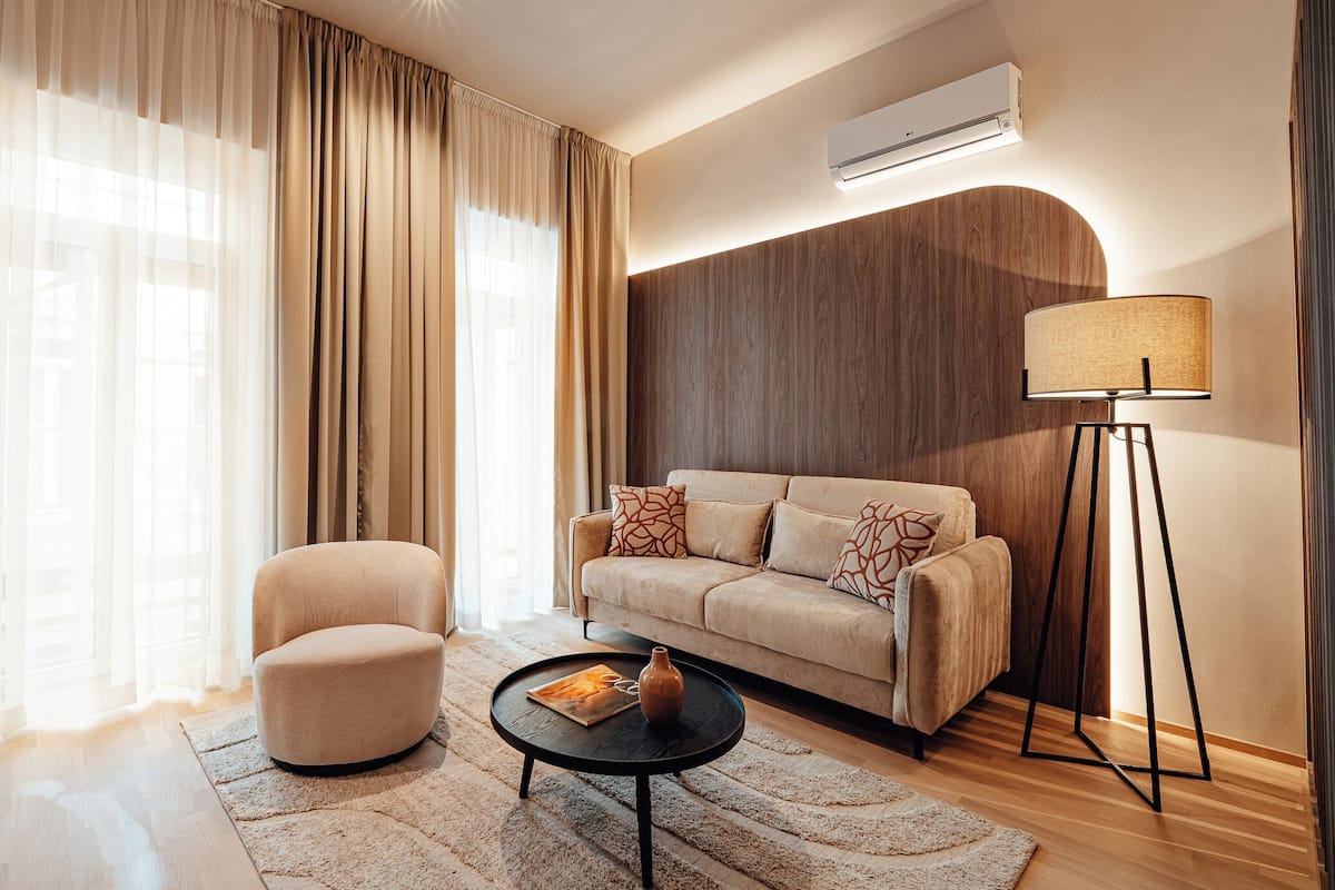 A modern living room with a sofa, armchair, coffee table, and floor lamp.