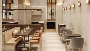 Un interior moderno con una larga zona de comedor, múltiples opciones de asientos y una cocina al fondo.