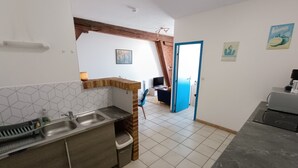 Une cuisine équipée d’un évier, d’une cuisinière et d’un coin repas avec une table.