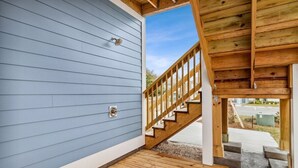 Eine Holztreppe führt zu einem Deck mit einem Metallgitter.