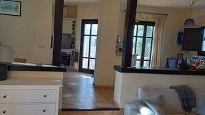 Eine Küche mit Herd, Backofen und Spüle. Ein Essbereich mit Tisch und Stühlen ist ebenfalls vorhanden.